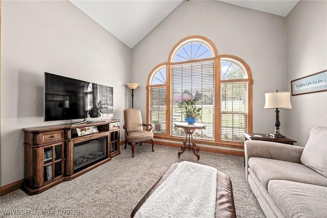 carpeted living area with high vaulted ceiling