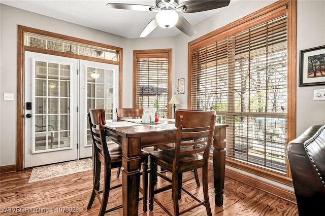 dining area featuring baseboards, a ceiling fan, and wood finished floors