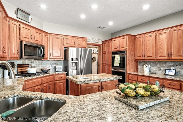 kitchen with recessed lighting, backsplash, appliances with stainless steel finishes, and a sink