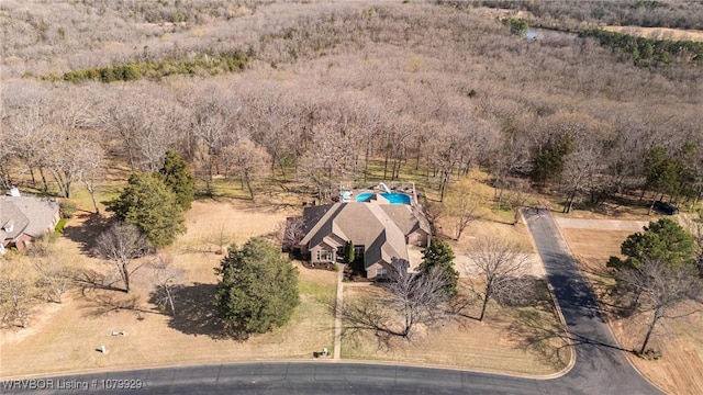 bird's eye view with a wooded view