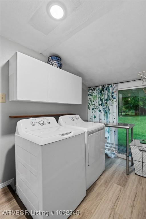 627 Parks Dr, Charleston, AR 72933 - washroom with washing machine and dryer, cabinet space, and light wood finished floors