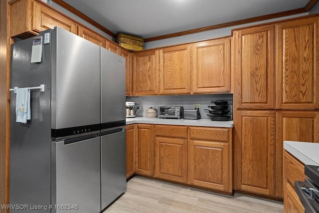 627 Parks Dr, Charleston, AR 72933 - kitchen featuring freestanding refrigerator, brown cabinets, light countertops, and ornamental molding