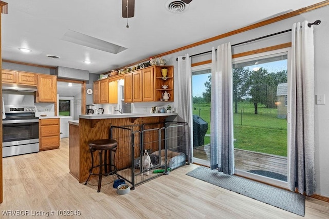 627 Parks Dr, Charleston, AR 72933 - kitchen featuring stainless steel range with electric stovetop, under cabinet range hood, light wood-type flooring, a kitchen bar, and open shelves