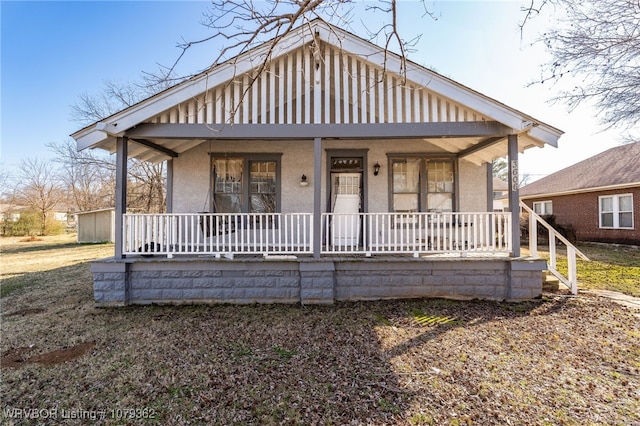 bungalow-style house with stucco siding and a porch