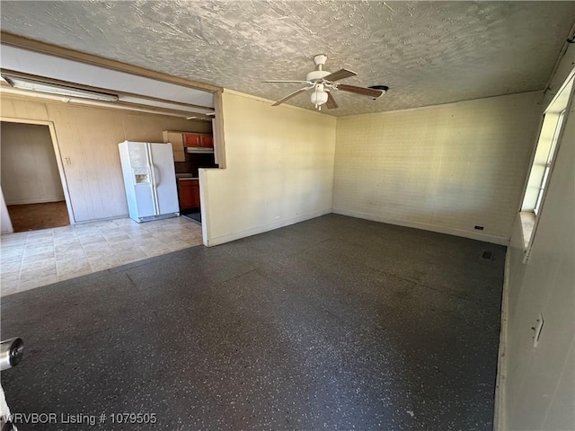 interior space with ceiling fan, baseboards, speckled floor, and a textured ceiling