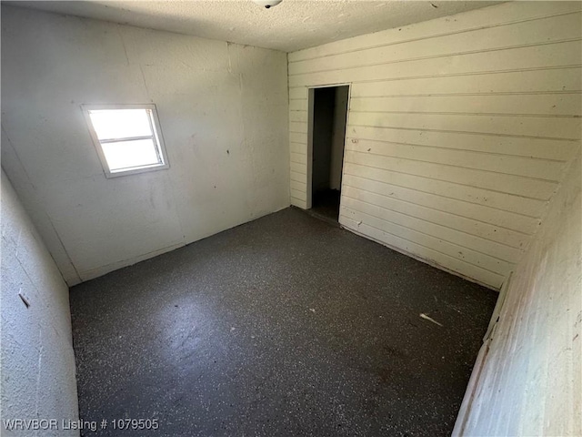 unfurnished room with a textured ceiling