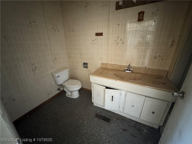 bathroom featuring vanity, toilet, visible vents, and baseboards