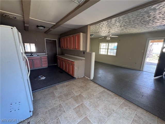 kitchen with visible vents, baseboards, freestanding refrigerator, a sink, and open floor plan