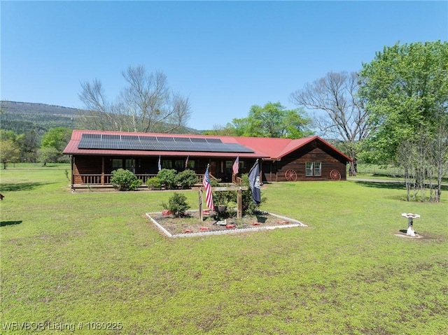 exterior space with a front lawn, metal roof, and solar panels