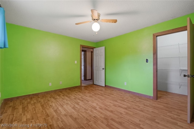 interior space featuring ceiling fan, light wood finished floors, and baseboards