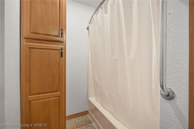 full bathroom featuring baseboards, shower / bath combination with curtain, and tile patterned floors