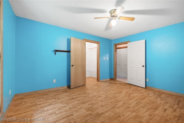 unfurnished bedroom featuring light wood-type flooring, a closet, baseboards, and a textured ceiling