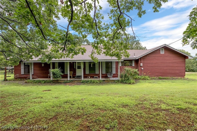 back of property featuring covered porch and a lawn