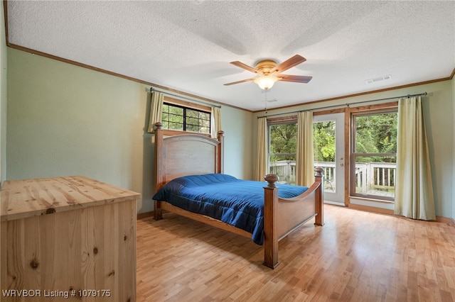 bedroom featuring light wood-type flooring, access to outside, multiple windows, and crown molding