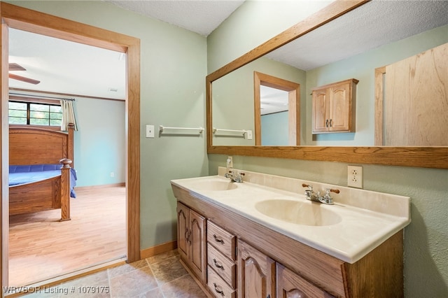 bathroom featuring a sink, a textured ceiling, and double vanity