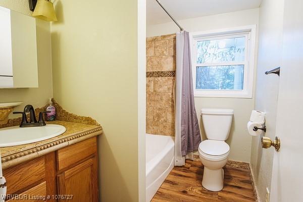 full bathroom with shower / bath combination with curtain, vanity, toilet, and hardwood / wood-style floors