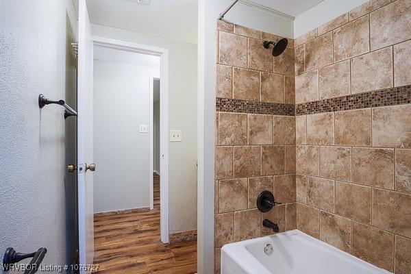 bathroom featuring tiled shower / bath combo and hardwood / wood-style flooring