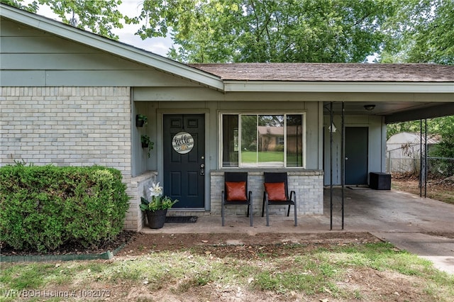 1008 Pattie Ln, Barling, AR 72923 - property entrance with brick siding, a carport, and a porch