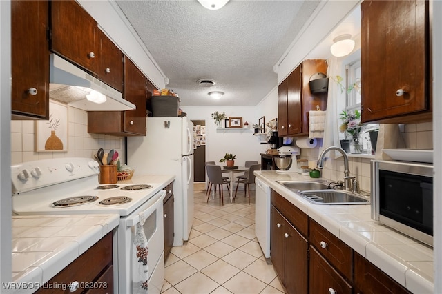 1008 Pattie Ln, Barling, AR 72923 - kitchen with white appliances, under cabinet range hood, tile countertops, a textured ceiling, and tasteful backsplash