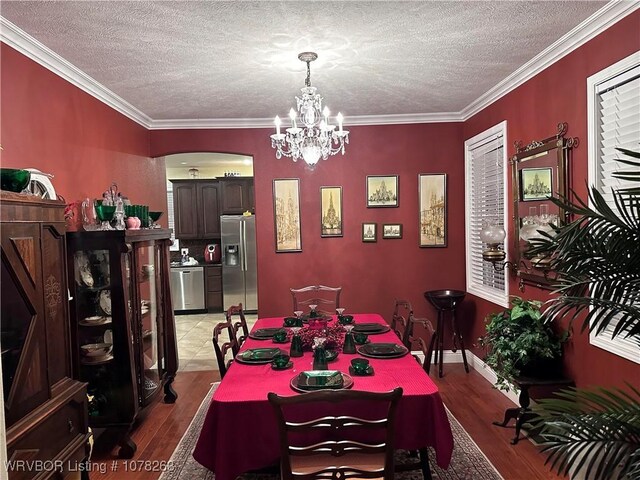 21 Bermuda Ct, Mountain Home, AR 72653 - dining area featuring arched walkways, light wood-style floors, a textured ceiling, a chandelier, and crown molding