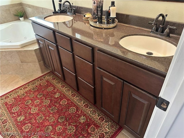 bathroom with vanity, tile patterned flooring, and tiled tub