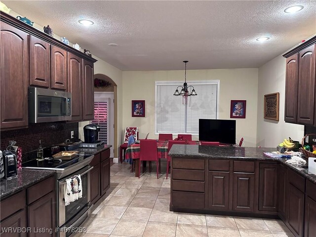21 Bermuda Ct, Mountain Home, AR 72653 - kitchen featuring appliances with stainless steel finishes, a textured ceiling, a peninsula, backsplash, and dark brown cabinetry
