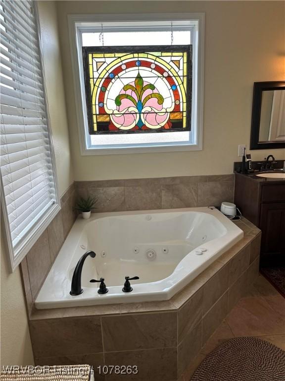 bathroom featuring vanity, tile patterned flooring, and tiled bath