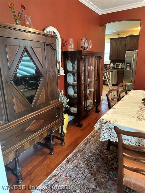 interior space featuring ornamental molding and dark wood-type flooring