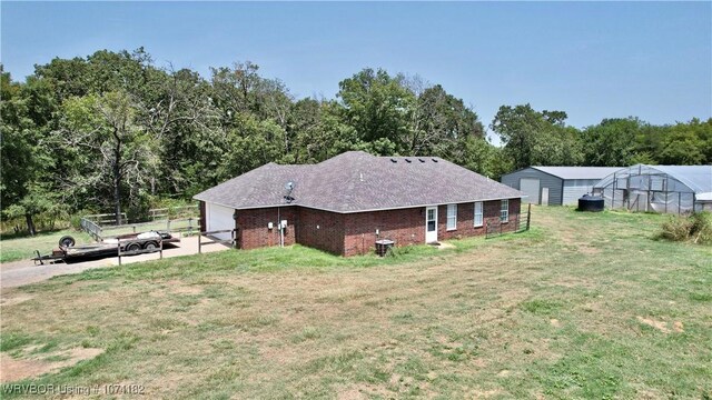 view of side of property featuring a lawn and an outbuilding