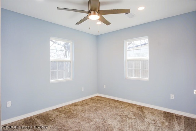 empty room with ceiling fan, a healthy amount of sunlight, and carpet