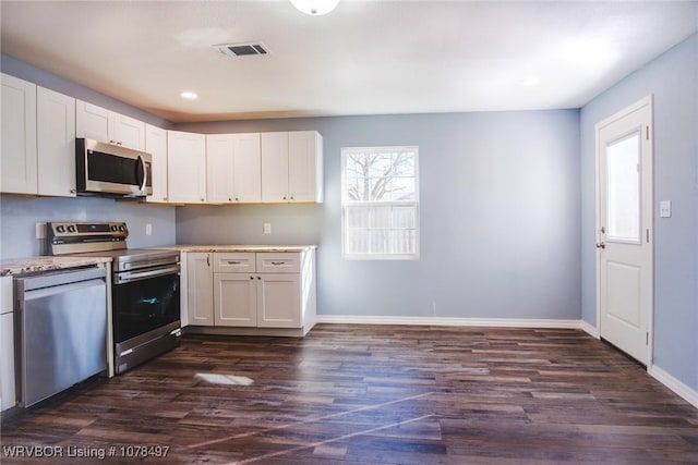 kitchen featuring dark wood-type flooring, stainless steel appliances, and white cabinets