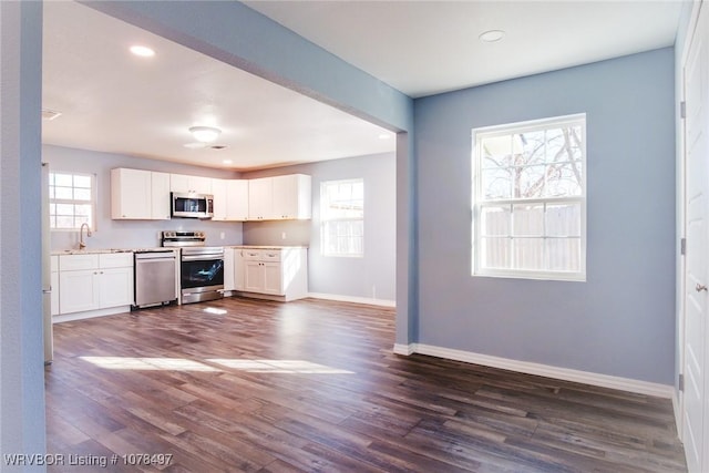 kitchen with white cabinetry, appliances with stainless steel finishes, dark hardwood / wood-style floors, and sink