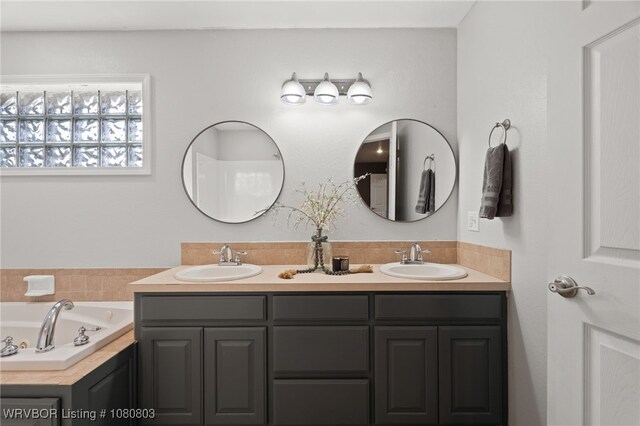 bathroom featuring a tub with jets and double vanity