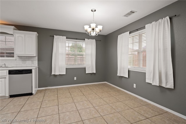 kitchen with stainless steel dishwasher, a chandelier, white cabinetry, light countertops, and decorative backsplash
