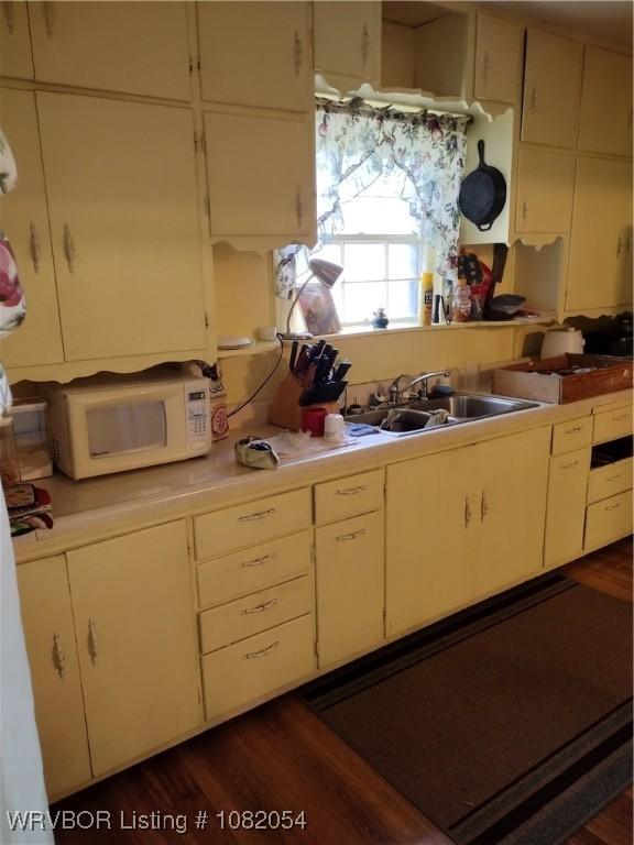 122 N Logan St, Charleston, AR 72933 - kitchen featuring white microwave, light countertops, and dark wood-style flooring