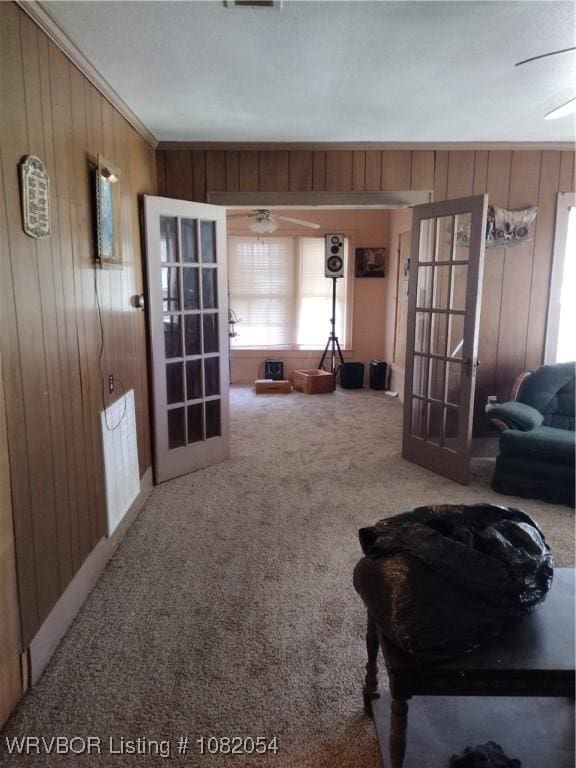 122 N Logan St, Charleston, AR 72933 - living room with french doors, wooden walls, carpet floors, and ceiling fan