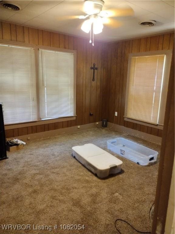 122 N Logan St, Charleston, AR 72933 - carpeted spare room featuring ceiling fan and wood walls