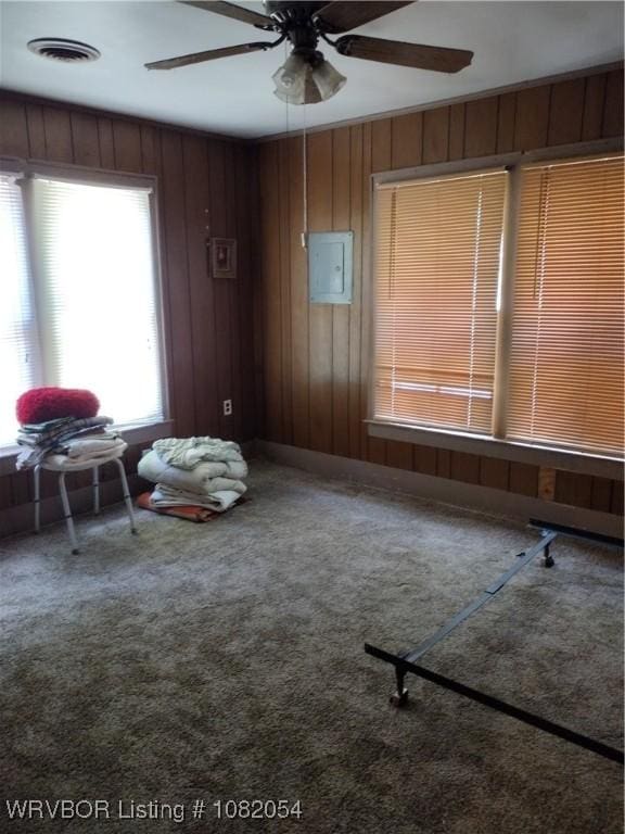 122 N Logan St, Charleston, AR 72933 - empty room featuring a ceiling fan, wooden walls, and carpet