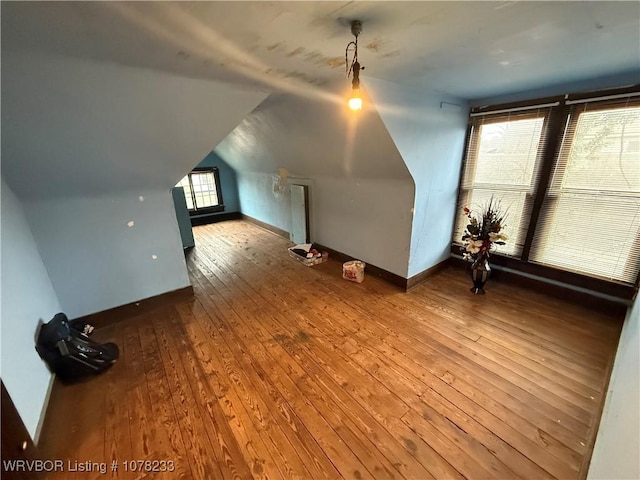 bonus room with wood-type flooring, vaulted ceiling, and a wealth of natural light