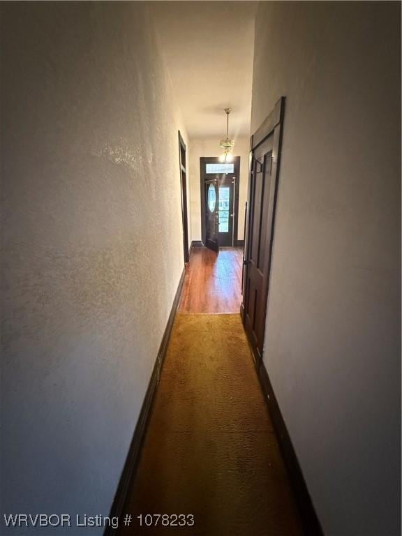 hallway featuring dark carpet