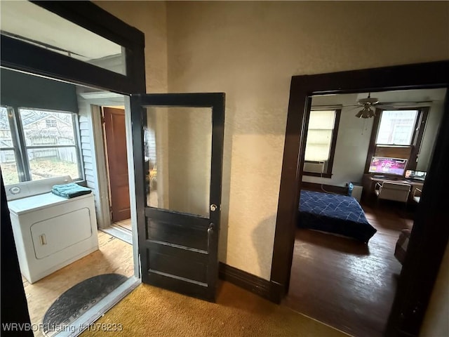 interior space featuring washer / dryer, light colored carpet, and ceiling fan