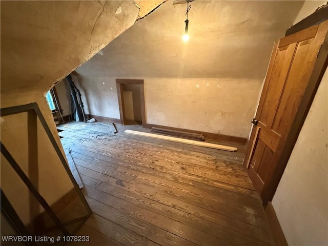 additional living space with hardwood / wood-style flooring