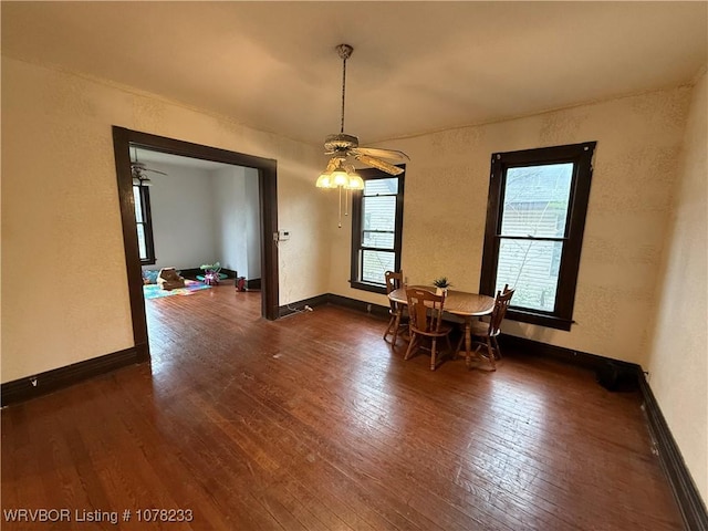 dining space featuring ceiling fan and dark wood-type flooring