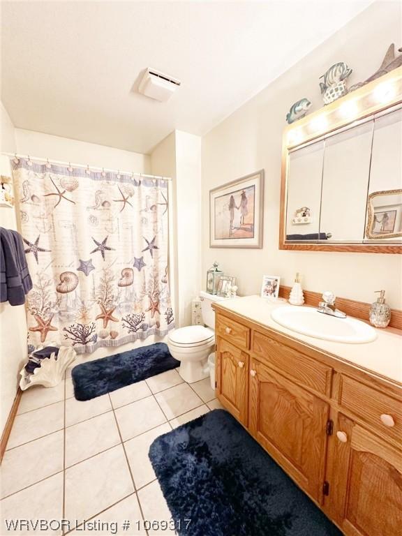 bathroom featuring tile patterned flooring, vanity, and toilet