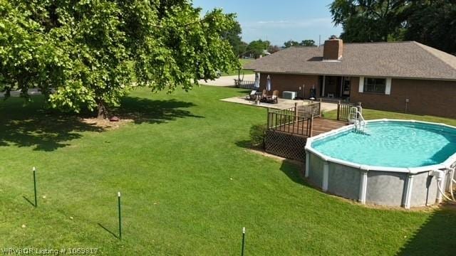 view of pool with a lawn and a deck