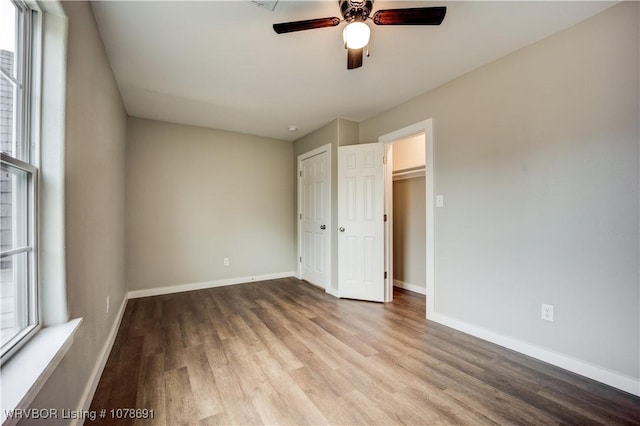 unfurnished bedroom featuring ceiling fan, wood-type flooring, and a closet