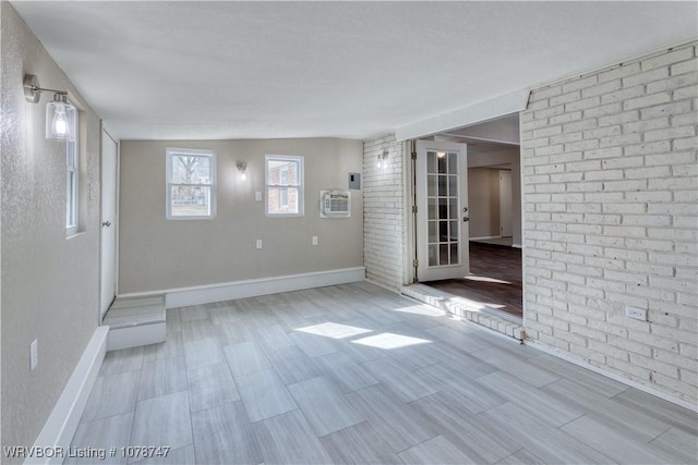 unfurnished room featuring brick wall and a wall mounted AC