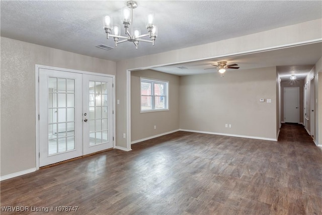 unfurnished room with french doors, ceiling fan with notable chandelier, dark wood-type flooring, and a textured ceiling