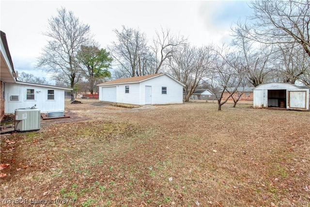 view of yard featuring cooling unit, a garage, and an outdoor structure