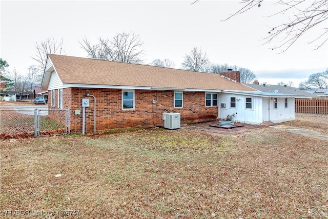 back of property with cooling unit and a lawn